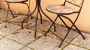 A small outdoor table with a potted plant, two chairs with patterned cushions, and a tiled floor. - Modern Family Apartment • AC • Free Parking • EV Charging  / Gorishka4Three (Ljubljana)