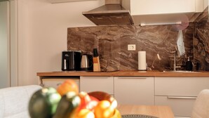 A modern kitchen with a marble backsplash, stainless steel appliances, and a wooden countertop. - Modern Family Apartment • AC • Free Parking • EV Charging  / Gorishka4Three (Ljubljana)