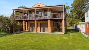 A two-story house with a balcony, brick exterior, and a garage.
