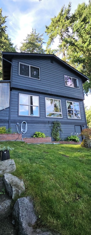 A two-story house with a sloped roof, multiple windows, and a well-maintained lawn.
