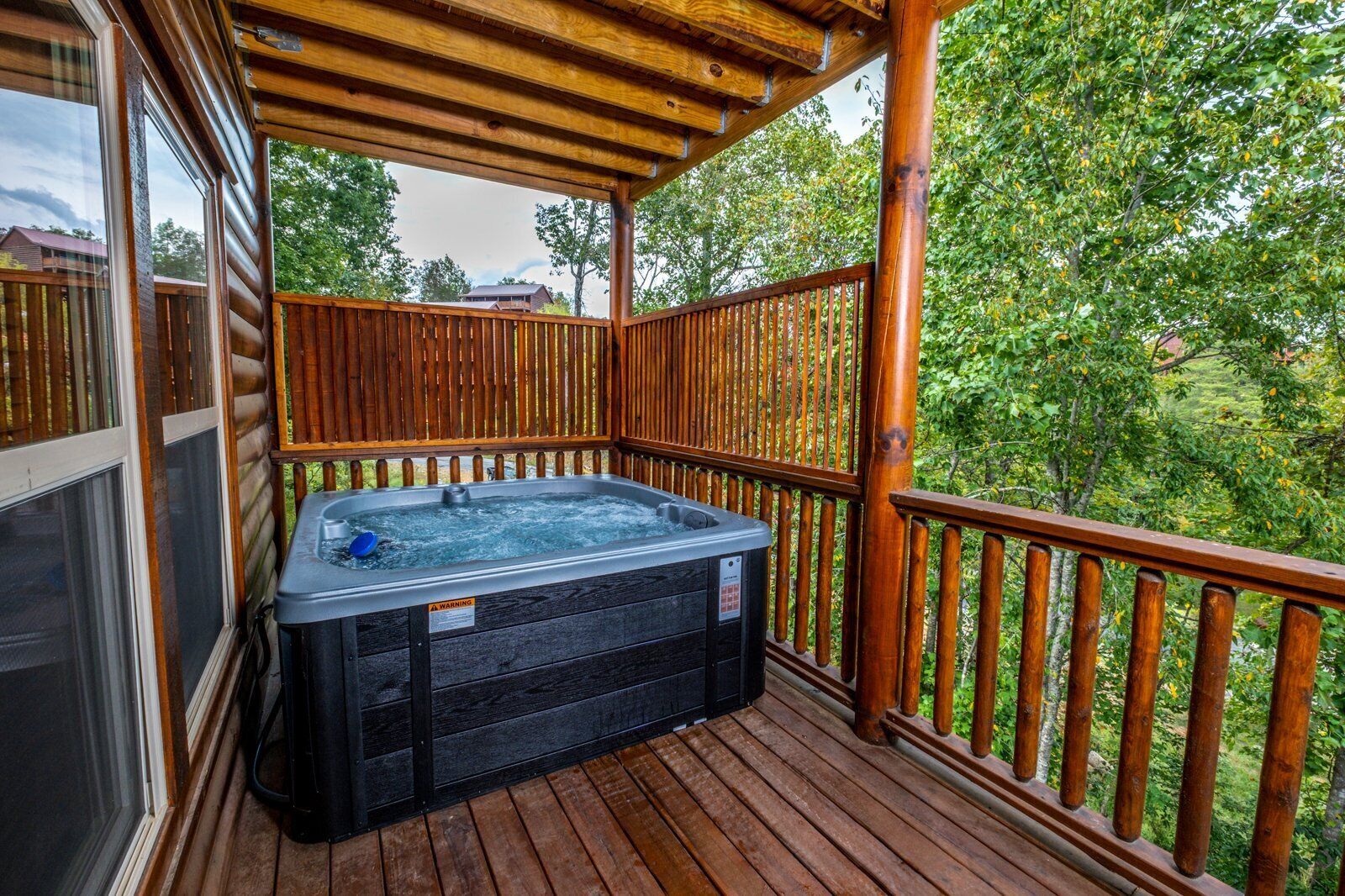 Eine Holzterrasse mit Whirlpool und Holzgeländer.