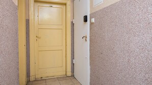A narrow hallway with a yellow door and a white door, both with simple handles.