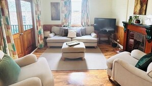 A living room with a sofa set, a coffee table, a fireplace, and a television. - 3BDR Blue Mountains Hideaway in Central Katoomba (Katoomba)