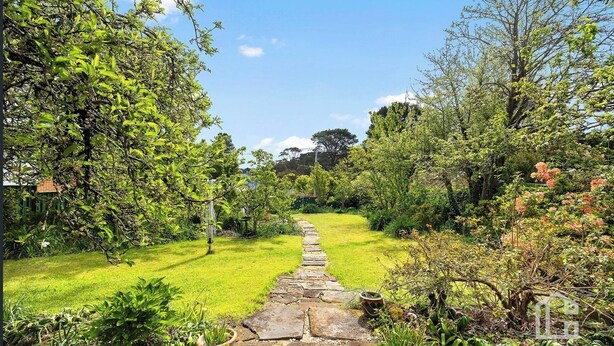 A stone pathway leading through a lush garden with various trees and shrubs. - 3BDR Blue Mountains Hideaway in Central Katoomba (Katoomba)