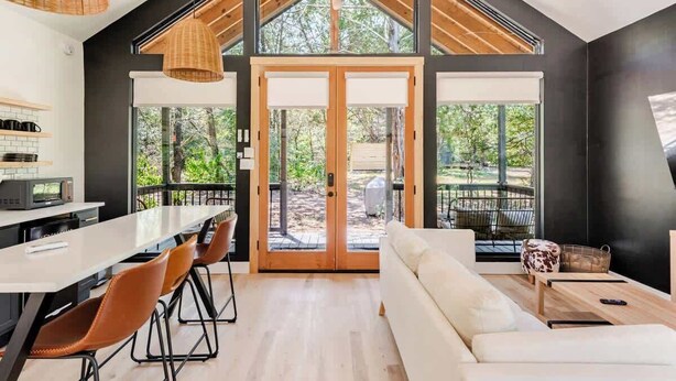 A modern kitchen with a large island, dining area with chairs, and a sofa. - Relaxing Ranch, Friendly Animals, Modern Stay (Cedar Creek)