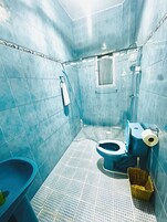 Un baño pequeño con azulejos, un inodoro, un bidé y una zona de ducha.