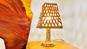 A wooden table with a woven lamp on top, positioned against a textured wall. - Ocean Colors Villa (San Pedro Pochutla)