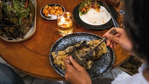 Una mesa de comedor con diversos platos, una vela y un número.