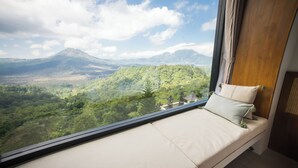 Una habitación con un amplio ventanal que ofrece vistas a un paisaje montañoso.