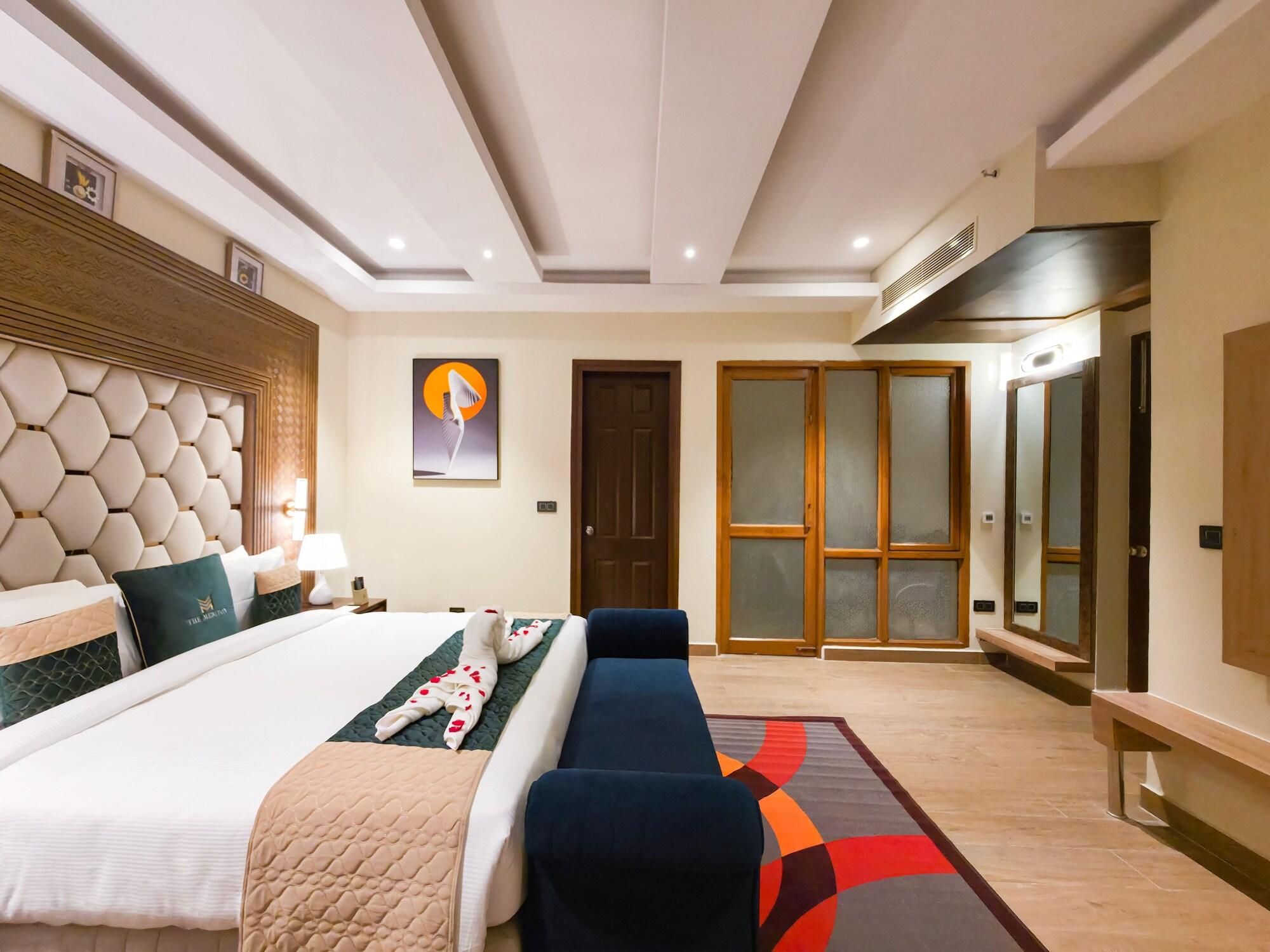 Una habitación de hotel con una cama grande, un sofá, un escritorio y un armario.