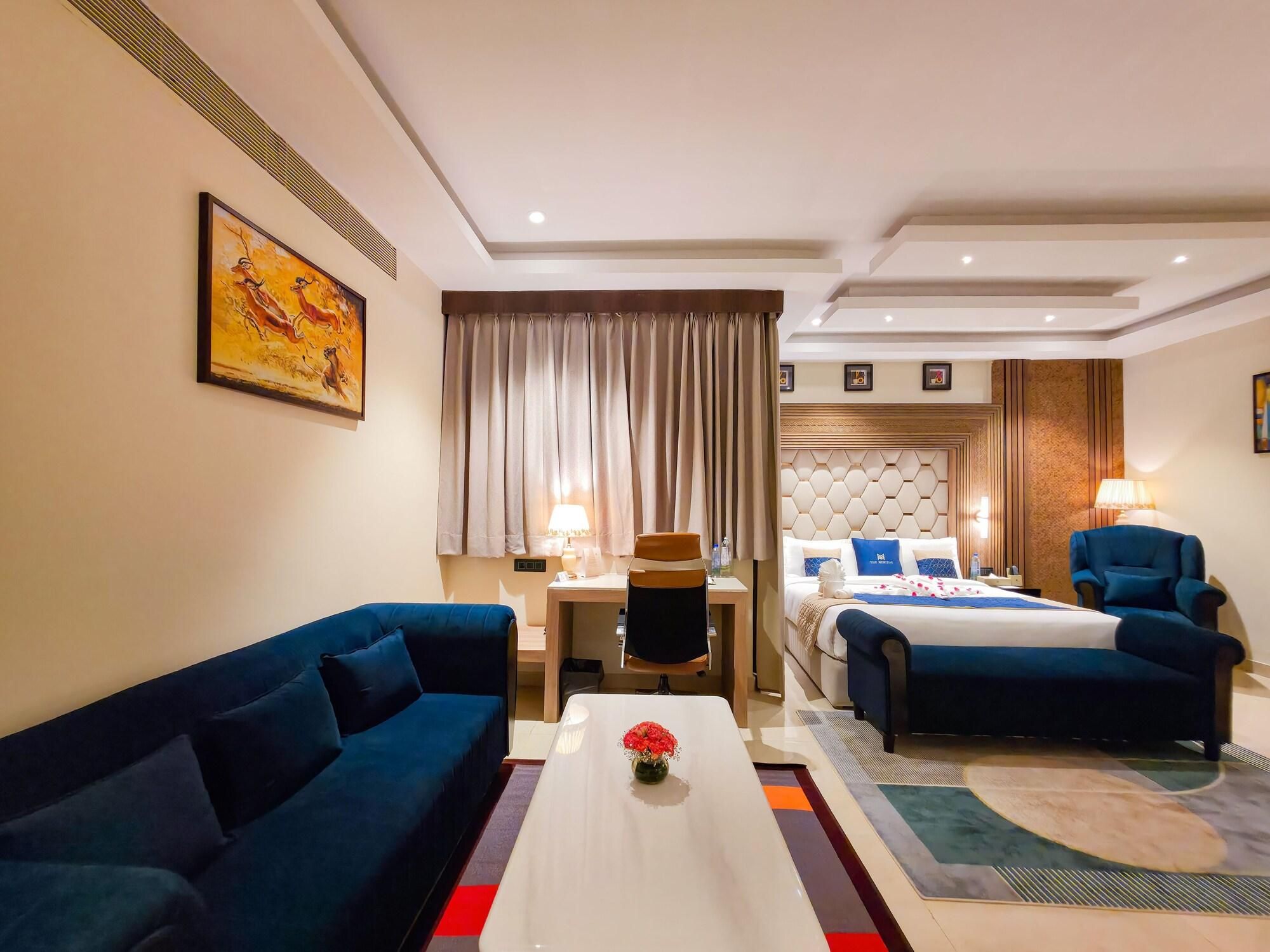 A hotel room with a sofa, a bed, a desk, and a coffee table.