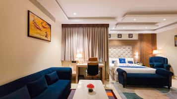 A hotel room with a sofa, a bed, a desk, and a coffee table.