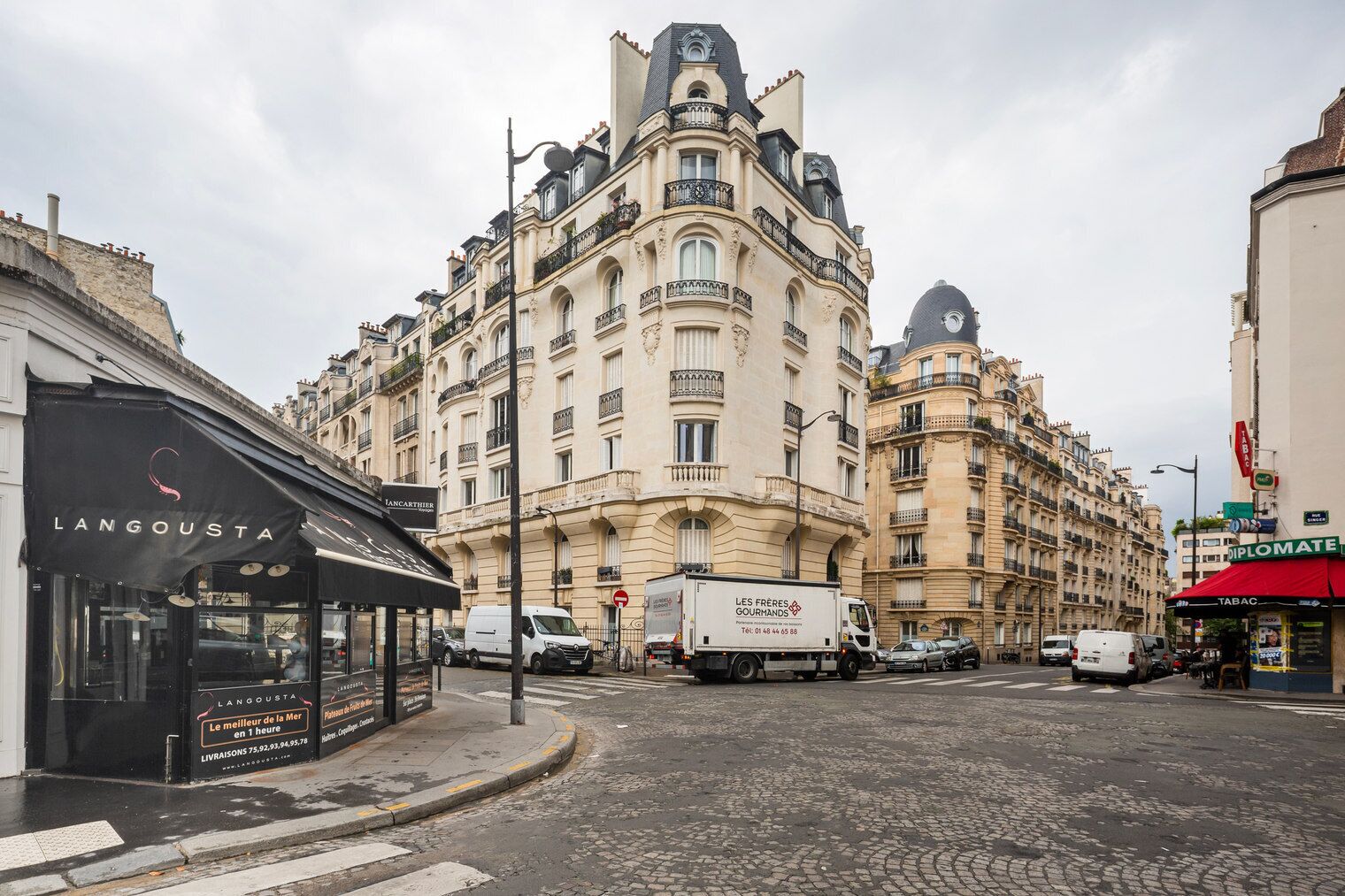 A street view with a building featuring ornate architecture and a storefront named 'LANGOUSTA.'