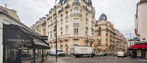 A street view with a building featuring ornate architecture and a storefront named 'LANGOUSTA.'