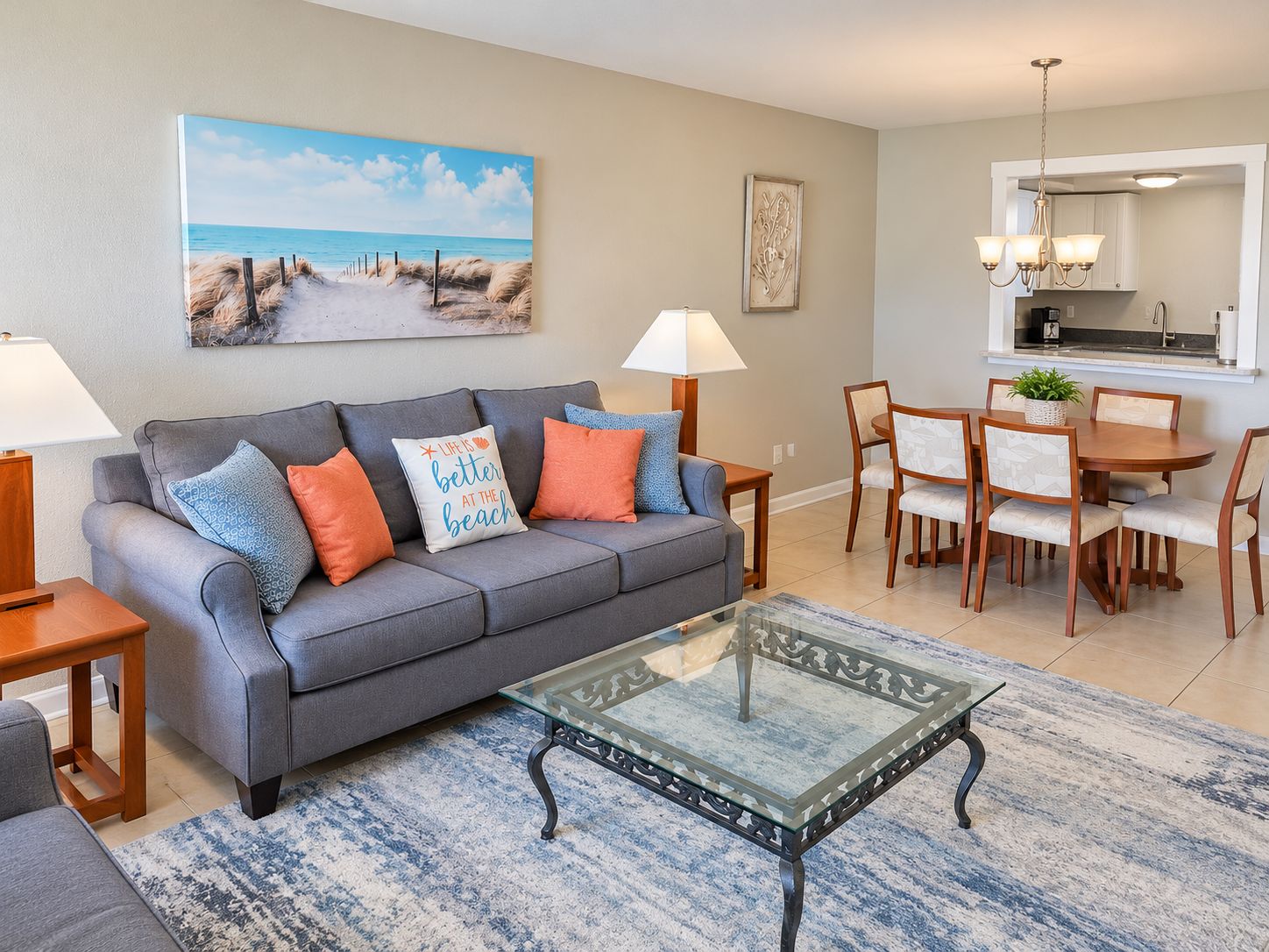 A living room with a sofa, coffee table, and dining area with chairs and a table.
