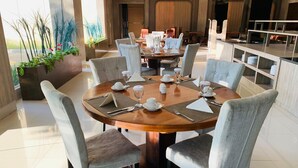 Un comedor moderno con una mesa redonda para seis personas, rodeada de sillas grises tapizadas.
