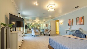 Une chambre à coucher avec un lit, une télévision, une commode et une chaise.