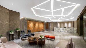 A modern lobby with a reception desk, seating area, and decorative wall. - Chengdu Yueming Hotel (Chengdu)