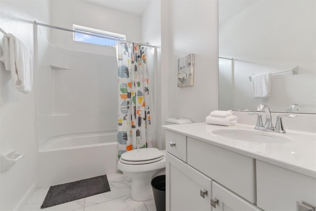 Un baño moderno con bañera, inodoro y lavamanos.