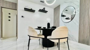 Un comedor moderno con una mesa redonda, dos sillas color beige y una mesa central negra.