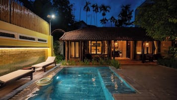 Una piscina al aire libre, sombrillas, tumbonas