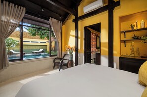 Een slaapkamer met een groot bed, uitzicht op een zwembad en een plankje met decoratieve objecten.