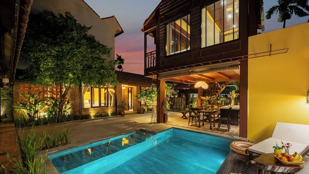 A poolside area with a swimming pool, outdoor seating, and a covered patio. - DEMIN VILLA HOI AN - Pool and BBQ Garden (Thanh pho Hoi An)