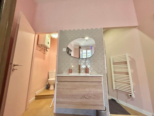 A bathroom with a white sink, a mirror, and a toilet.