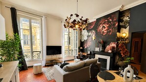 A modern living room with a sofa, dining table, and a TV.
