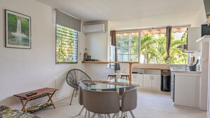 A modern kitchen with a dining area, a small table with a chair, and a sofa. - Studio Zaboka - Beaches & Marina Ideal for couples, many activities on foot! (Les Trois-Îlets)