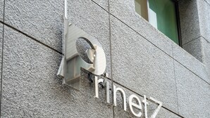 Eine Gebäudefassade mit einem metallenen Schild, auf dem "Rinetz" steht.