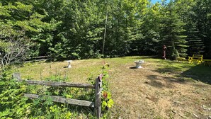 A rustic outdoor area with a wooden fence, a birdbath, and a bench. - Fall Lakefront Escape on Monocle Lake with Private Dock + Bunkhouse (Brimley)
