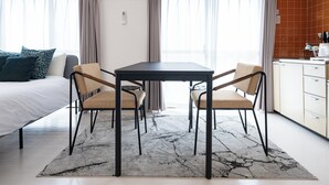 A modern hotel room with a bed, a dining table with chairs, a kitchen area, and large windows with curtains. - PrinetzShinjuku4F (Tokyo)