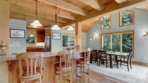 Un interior de madera con barra, mesa de comedor y sillas.
