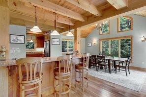 Un intérieur en bois comprenant un bar, une table à manger et des chaises.