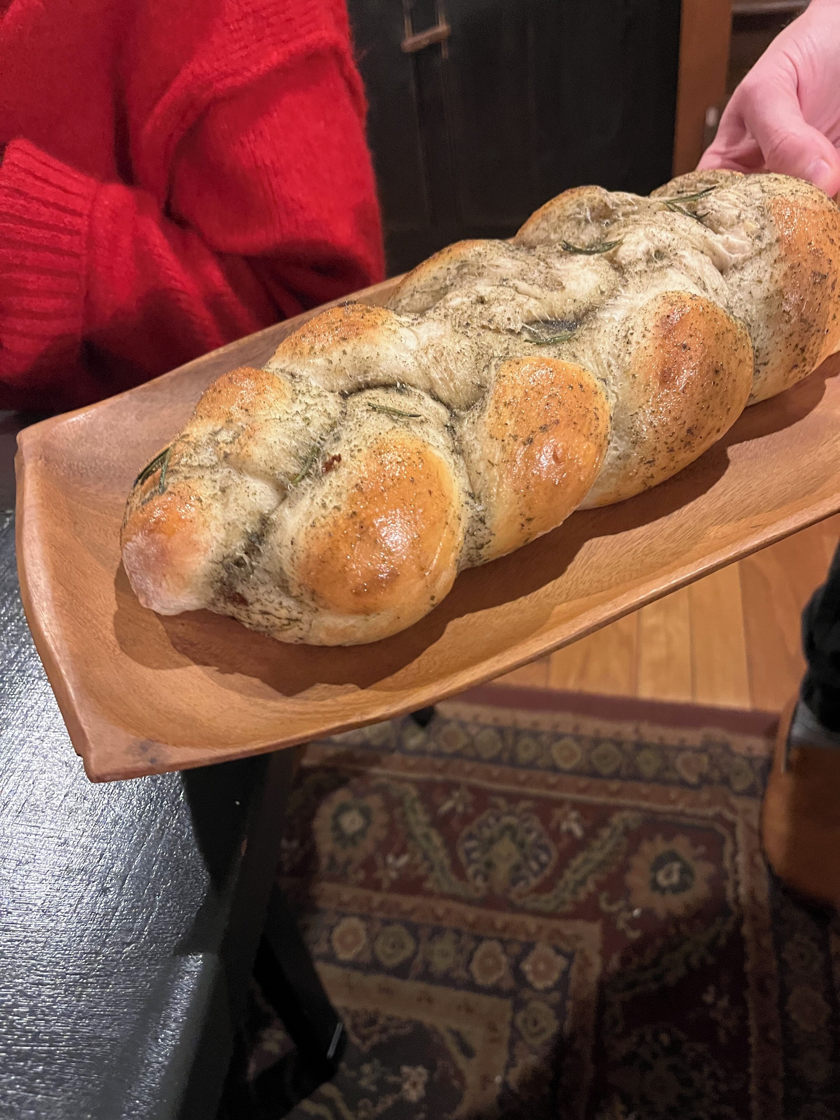 Een houten dienblad met een rustiek brood.