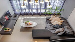 Ein modernes Wohnzimmer mit einer Couch, einem Couchtisch und einem Fernseher.