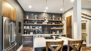 A modern kitchen with a stainless steel refrigerator, wooden chairs, and a central island. - Eagle-Vail Escape | 3BR Near Skiing & Trails (Vail)
