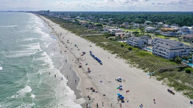 A beach with a row of houses and a pier. - Sea Cloisters 105b (North Myrtle Beach)
