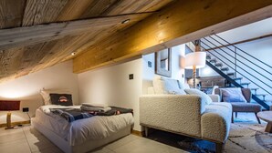 Une chambre à coucher avec un lit, un canapé, une lampe et un escalier.
