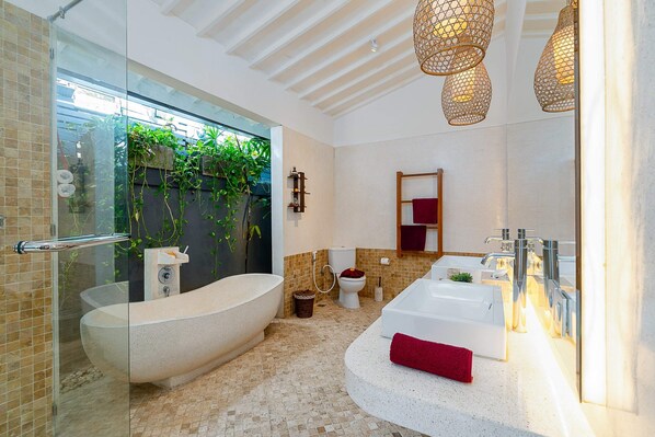 A modern bathroom with a freestanding bathtub, a double sink vanity, and a glass-enclosed shower area. - Villa Yang Tao 4 (Seminyak)