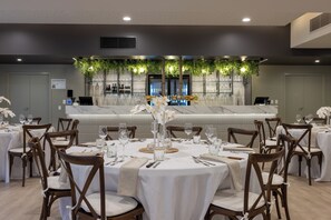 Ein Restaurant mit runden Tischen, Stühlen und einer Theke im Hintergrund.
