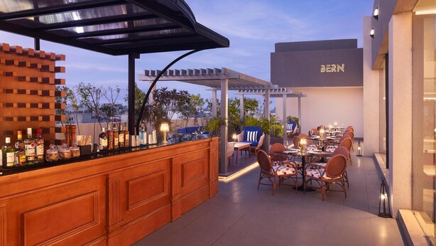 An outdoor dining area with a bar, tables, and chairs.