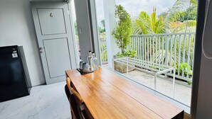 Una cocina moderna con una mesa y sillas de madera, un refrigerador y una puerta con el número 6.