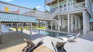 A multi-level pool area with lounge chairs and a covered deck. - Dreams Float, Private Heated Pool/Hot Tub, Pier (Jamaica Beach)