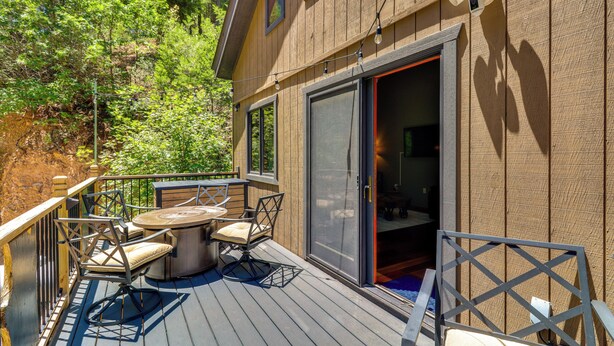 A wooden deck with outdoor furniture, a sliding glass door, and a view of a forested area. - Quiet Cabin Retreat: Minutes from Cloudcroft! (Cloudcroft)