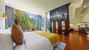 A modern hotel room with a large bed, a balcony with a mountain view, and a poster on the wall. - Huagu Jianzhu Guesthouse Zhangjiajie (Zhangjiajie)
