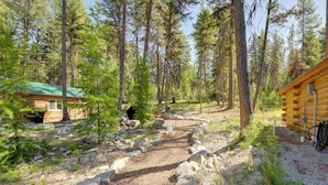 A cabin surrounded by a forest with a gravel path leading to it. - McGregor Lake Access: Cabin in Wooded Wilderness (Marion)