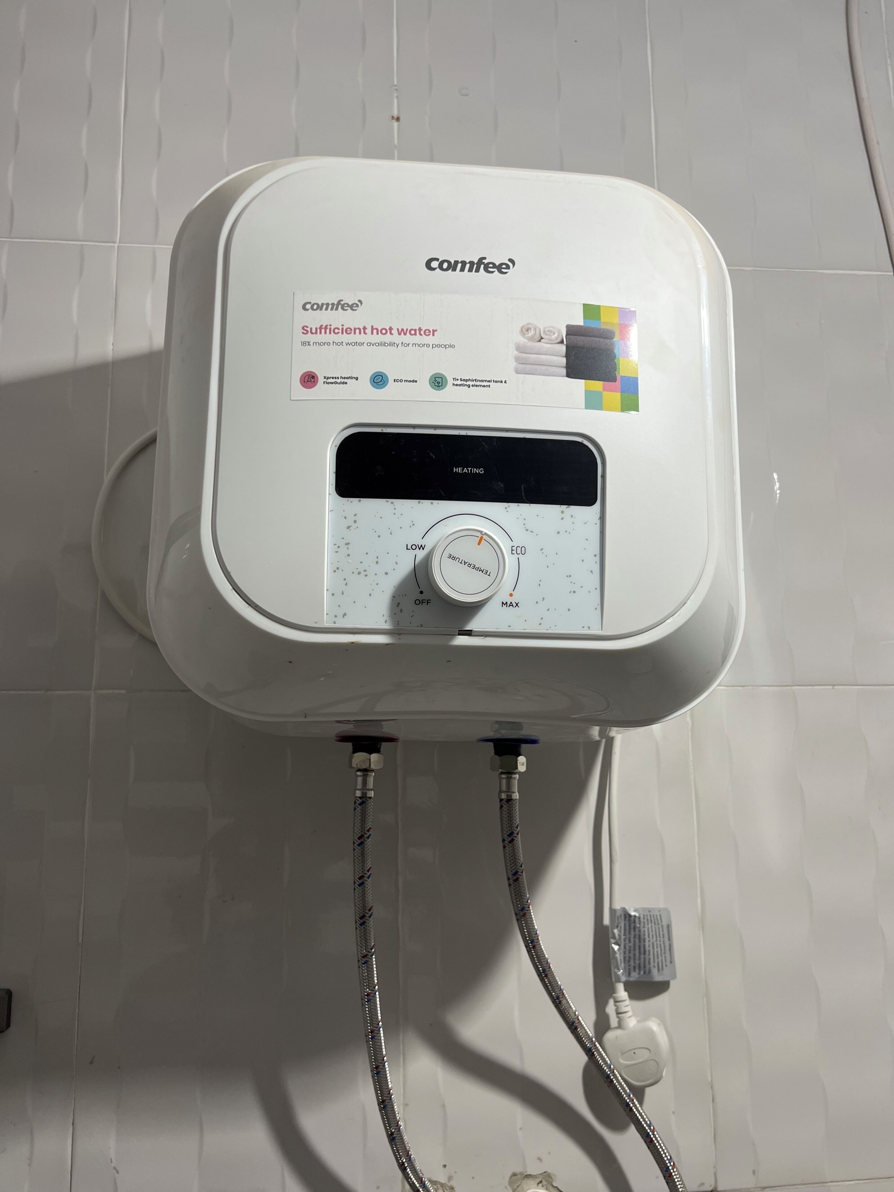 Un calentador de agua Comfee blanco con panel de control, dos mangueras y un enchufe.