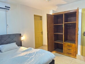 Une chambre à coucher avec un lit, une armoire et une porte.